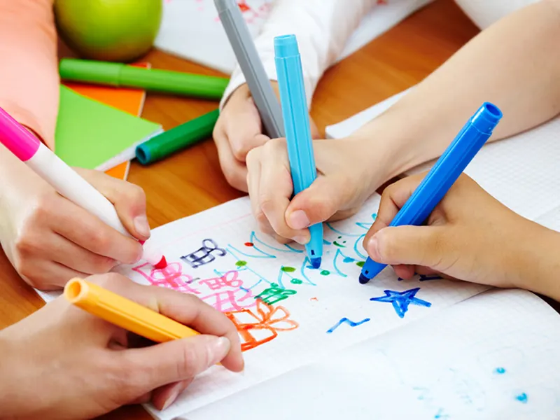 Children's hands drawing with felt-tip pens