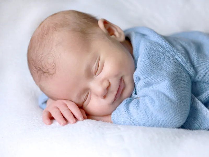 A baby smiling in their sleep