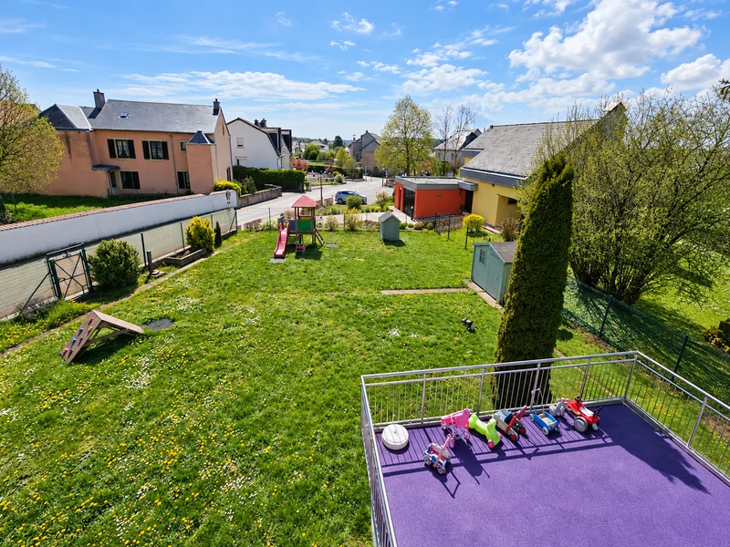 A view over the nursery garden, with play equipment and the purple terrace